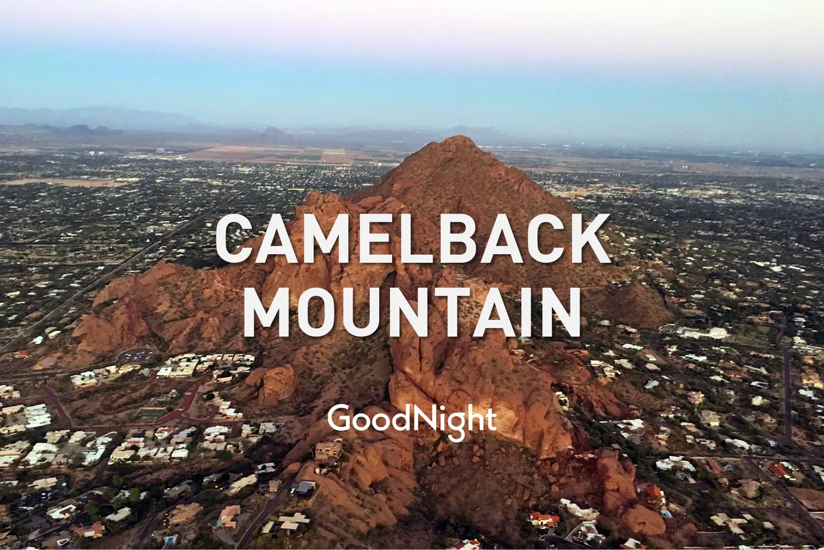 A scenic wide-angle shot of Camelback Mountain rising above the surrounding neighborhood, with a tranquil, sunlit atmosphere perfect for hiking and nature outings.